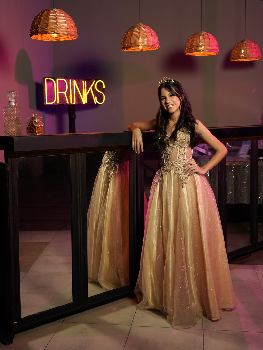 Quinceañera en salón de fiesta, retrato junto a la barra iluminada
